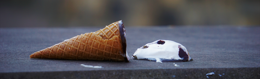 ice cream cone on side with ice cream spilled